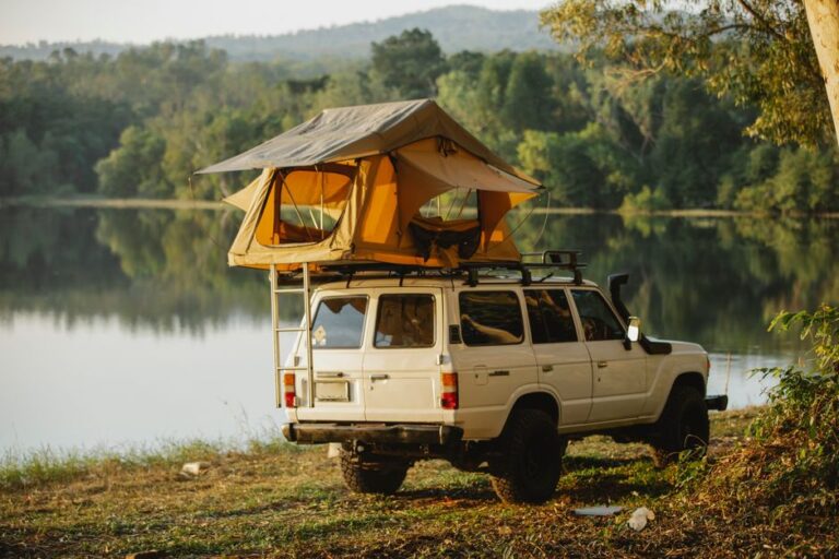 Rooftop Tent 4x4 Tanzania Cost: What Really Changes the Price? 1 Off-road vehicle with rooftop tent parked by a lake